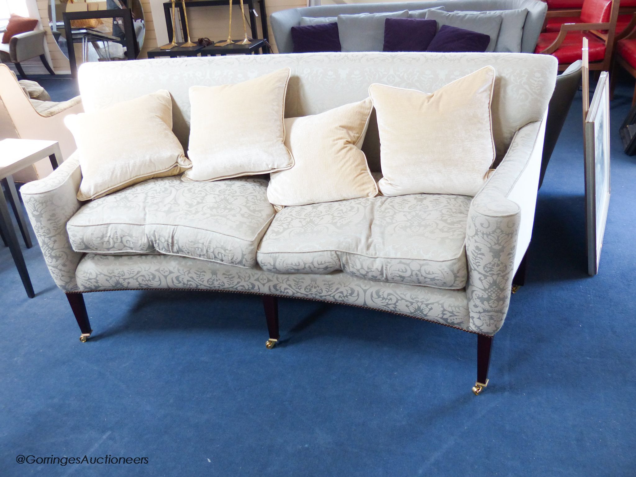 A pair of George III style eau de nil silk damask concave fronted two seat sofas, on square tapered mahogany legs with brass casters, approximately 188 cm wide
